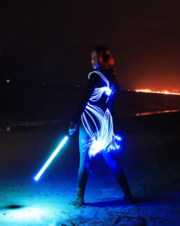 unnaturalglow-livewire-fiber-optic-bodysuit-light-up-sword-on-beach